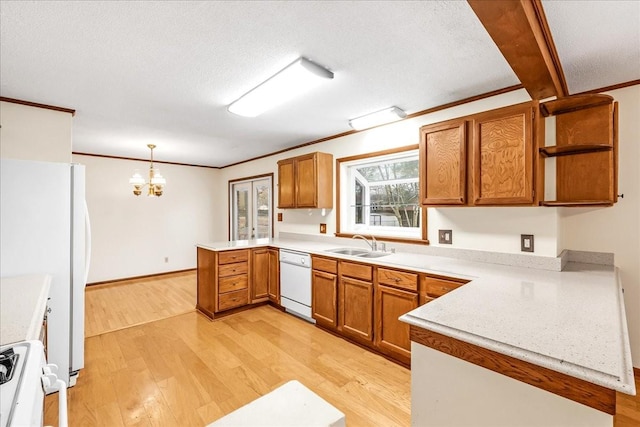 kitchen with sink, hanging light fixtures, light hardwood / wood-style flooring, kitchen peninsula, and white appliances