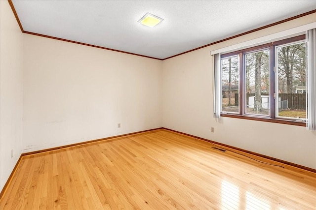 spare room with ornamental molding, wood-type flooring, and a textured ceiling