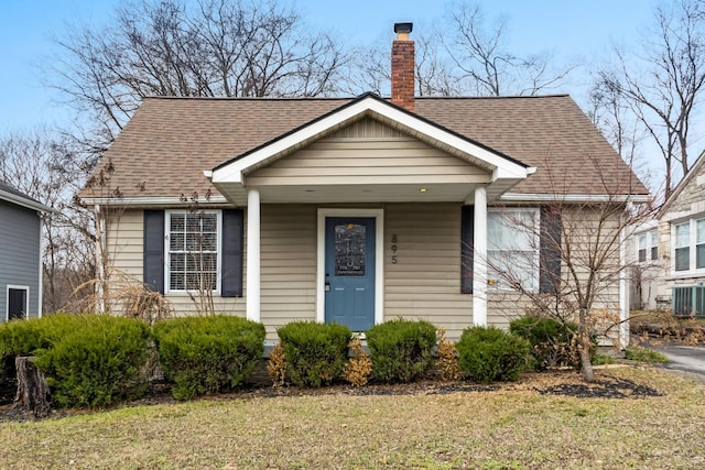 view of front of home with central AC and a front lawn