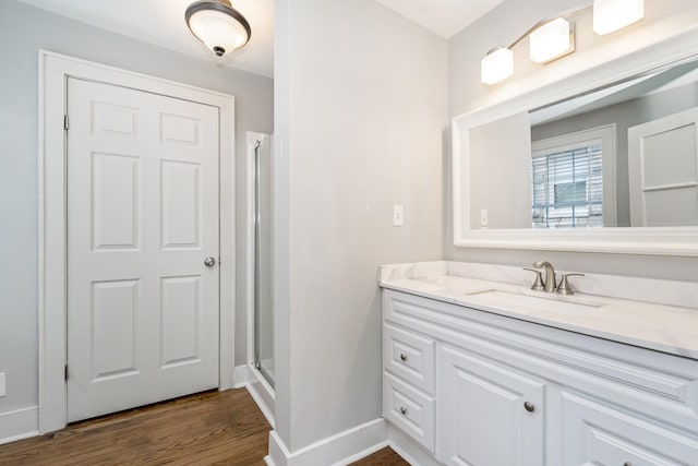 bathroom with vanity, a shower with shower door, and wood-type flooring