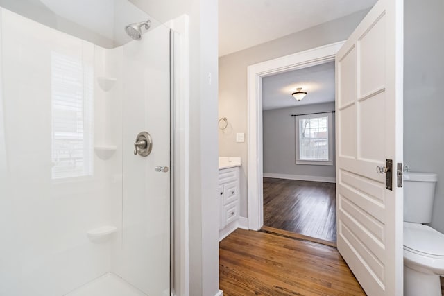 bathroom featuring vanity, hardwood / wood-style floors, walk in shower, and toilet