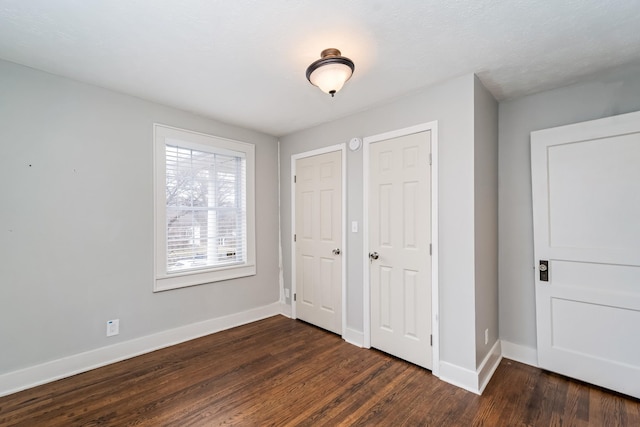 unfurnished bedroom with dark hardwood / wood-style floors