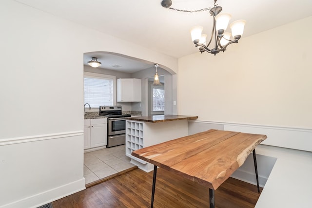 dining room with sink, an inviting chandelier, and light hardwood / wood-style flooring