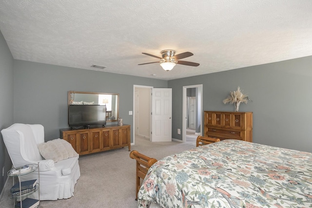 bedroom featuring ceiling fan, light carpet, and a textured ceiling