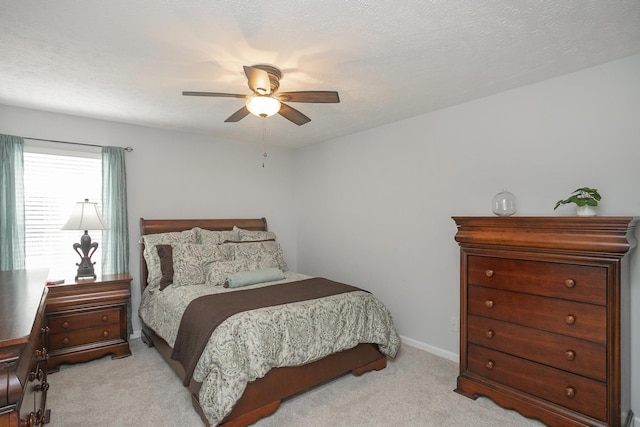 bedroom with ceiling fan, light carpet, and a textured ceiling