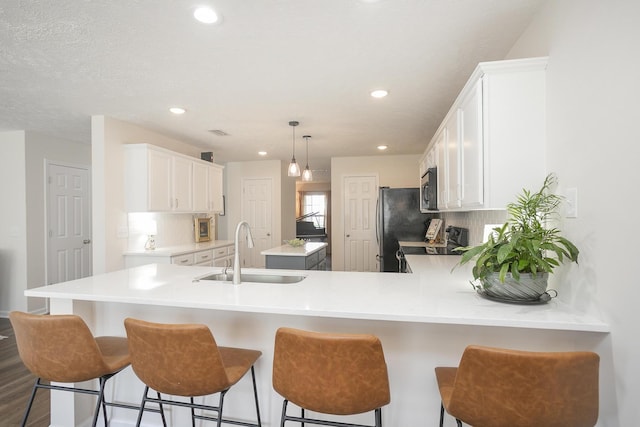 kitchen with sink, backsplash, stainless steel appliances, and white cabinets