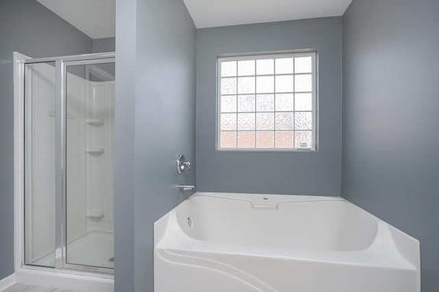 bathroom featuring shower with separate bathtub