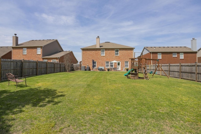 rear view of house featuring a lawn, a playground, and central air condition unit