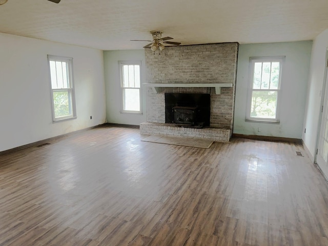 unfurnished living room featuring visible vents, ceiling fan, baseboards, and wood finished floors