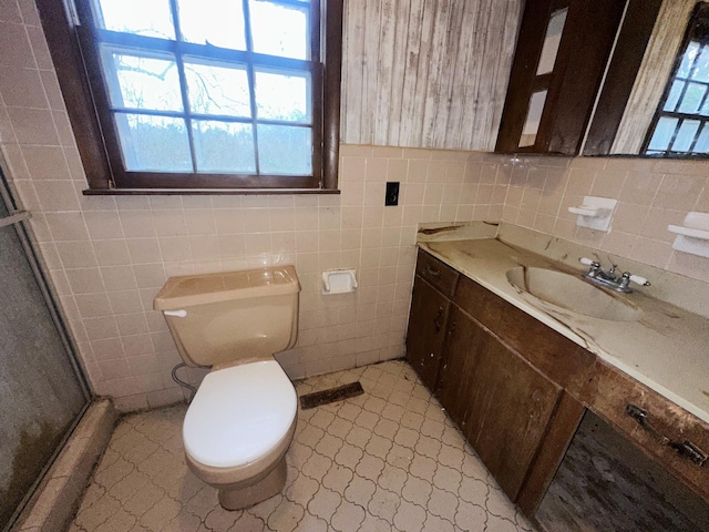 full bath featuring toilet, a shower stall, tile walls, and vanity