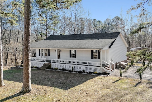 view of front facade featuring cooling unit, covered porch, and a front yard