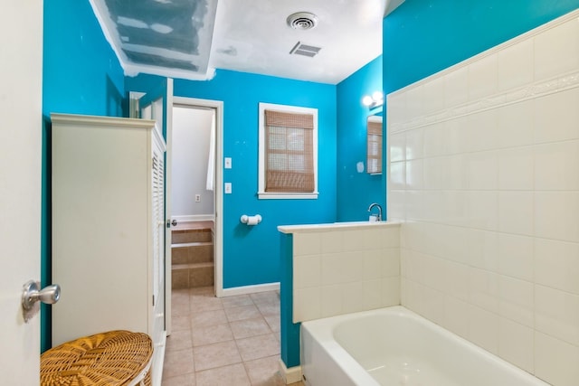 bathroom featuring tile patterned flooring and a washtub