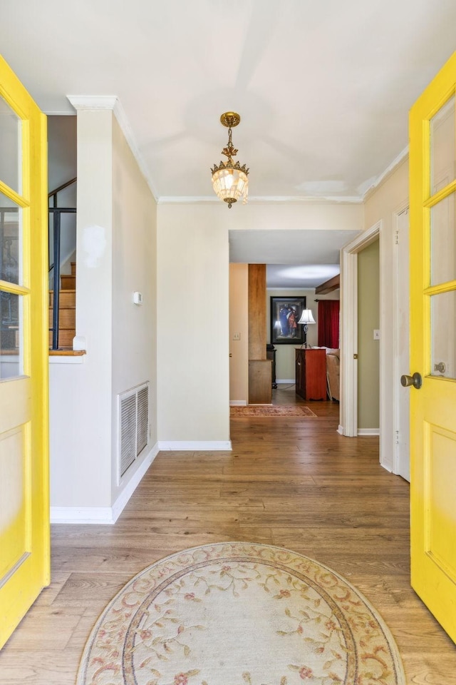 interior space with hardwood / wood-style floors and ornamental molding