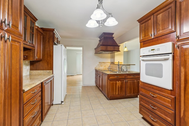 kitchen featuring pendant lighting, white appliances, premium range hood, and sink