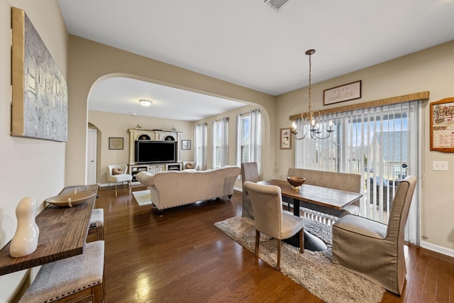 dining area with an inviting chandelier and dark hardwood / wood-style flooring