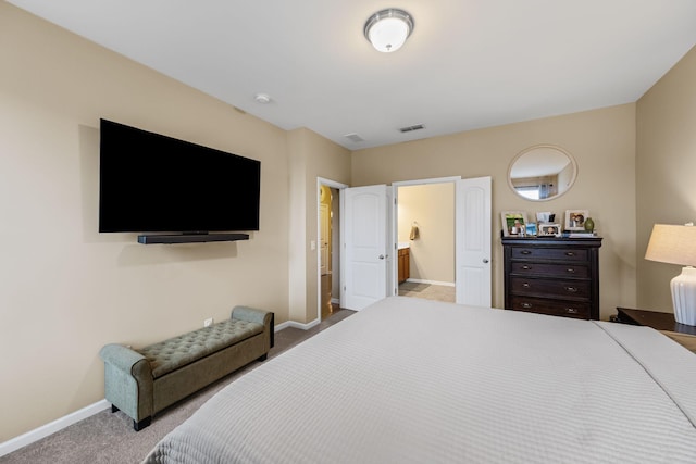 bedroom with connected bathroom and light colored carpet