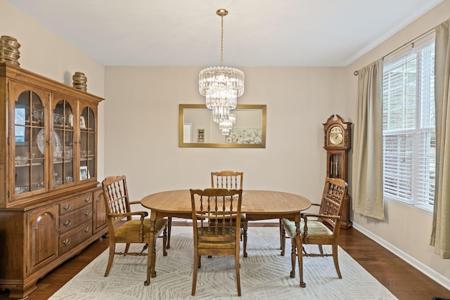 dining area with dark wood-type flooring and a chandelier