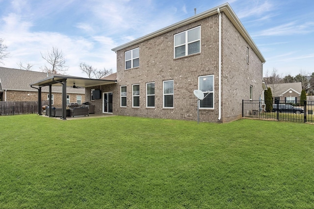 back of property with ceiling fan, an outdoor living space, a patio area, and a lawn