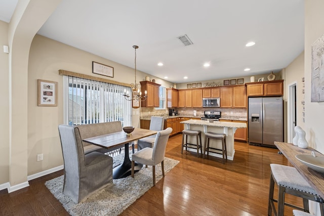 dining area featuring an inviting chandelier and dark hardwood / wood-style flooring