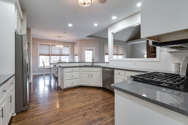 kitchen with sink, hanging light fixtures, stainless steel appliances, white cabinets, and kitchen peninsula