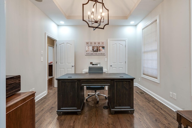 office area with a raised ceiling, dark hardwood / wood-style floors, and a chandelier