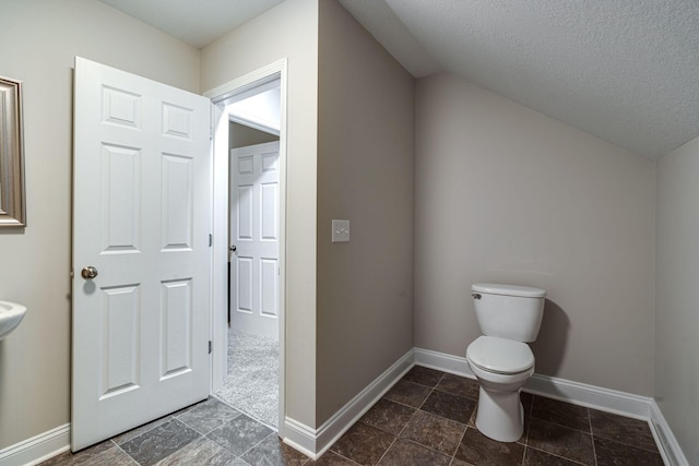 bathroom featuring a textured ceiling and toilet