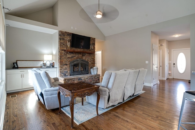 living room featuring dark hardwood / wood-style floors, ceiling fan, a fireplace, and high vaulted ceiling