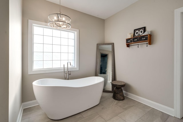 bathroom with tile patterned flooring, a chandelier, and a bathtub