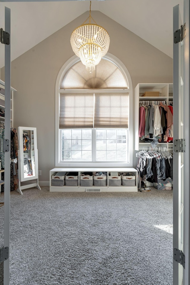 interior space featuring vaulted ceiling, carpet, and a notable chandelier