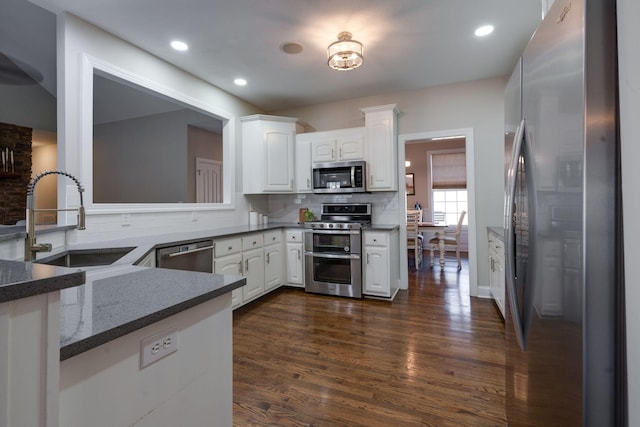 kitchen with white cabinetry, sink, kitchen peninsula, and appliances with stainless steel finishes