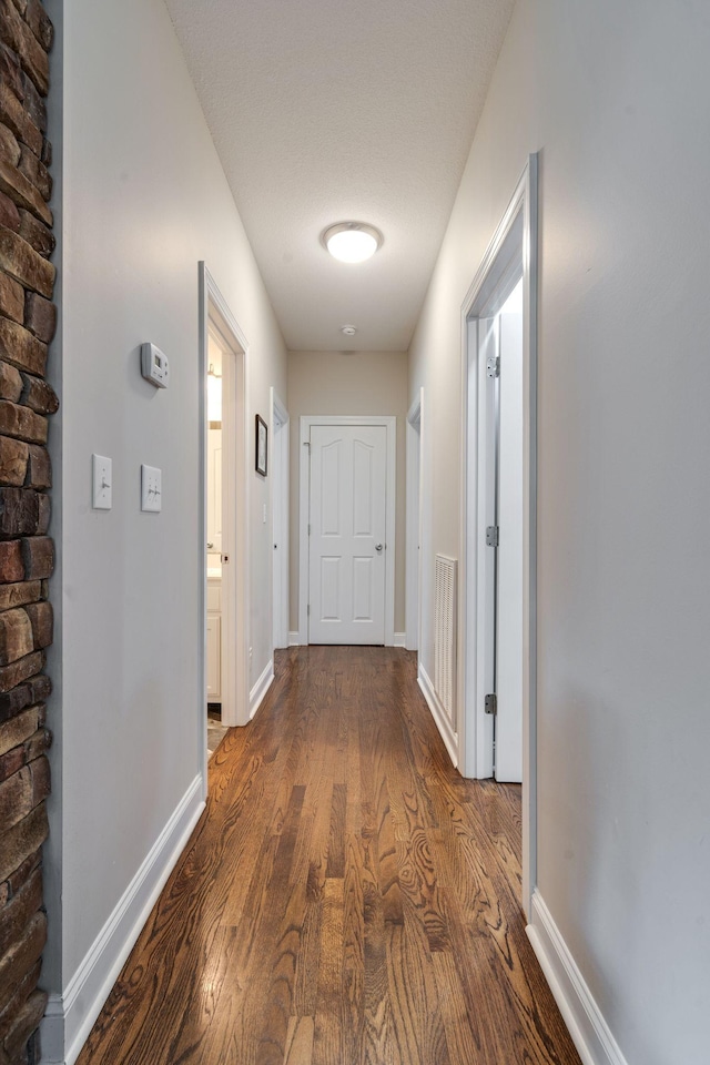 hallway with hardwood / wood-style flooring