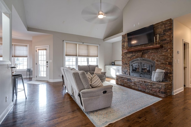 living room featuring dark wood-type flooring, a fireplace, high vaulted ceiling, and ceiling fan