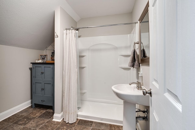 bathroom with lofted ceiling, a textured ceiling, and a shower with curtain