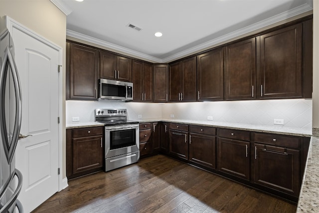 kitchen featuring appliances with stainless steel finishes, tasteful backsplash, dark hardwood / wood-style flooring, dark brown cabinetry, and light stone counters