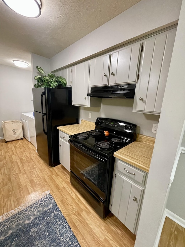 kitchen featuring a textured ceiling, light hardwood / wood-style flooring, black appliances, and washing machine and dryer