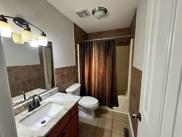 full bathroom featuring shower / bathtub combination with curtain, tile walls, vanity, a textured ceiling, and tile patterned floors