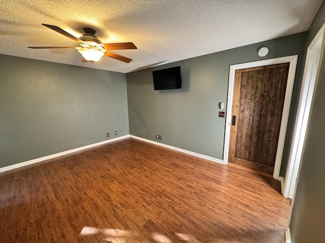 empty room featuring hardwood / wood-style flooring, ceiling fan, and a textured ceiling