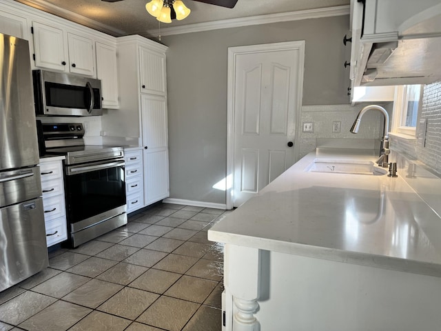 kitchen featuring sink, white cabinetry, crown molding, stainless steel appliances, and backsplash