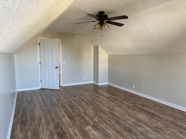 additional living space with ceiling fan, lofted ceiling, dark hardwood / wood-style flooring, and a textured ceiling