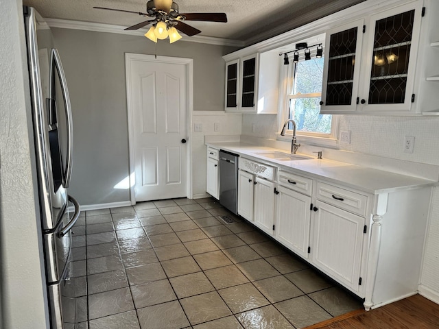 kitchen featuring white cabinetry, sink, backsplash, stainless steel appliances, and crown molding