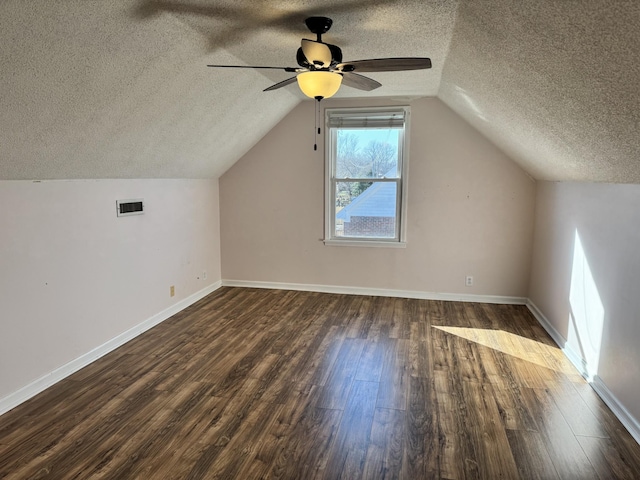 bonus room featuring vaulted ceiling, dark wood-type flooring, ceiling fan, and a textured ceiling