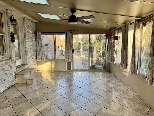 unfurnished sunroom featuring ceiling fan and vaulted ceiling