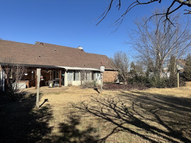 back of house featuring a lawn and a patio