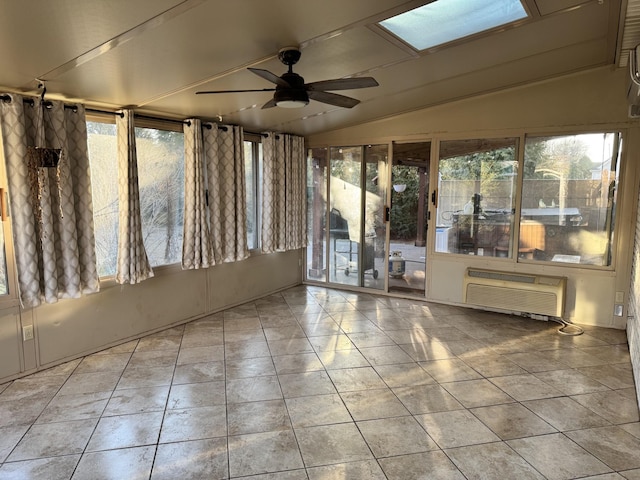 unfurnished sunroom featuring lofted ceiling with skylight, a wall mounted air conditioner, and ceiling fan