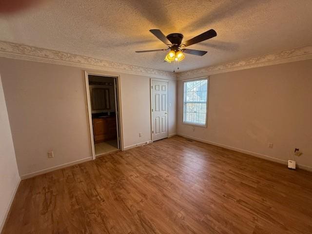 unfurnished bedroom featuring hardwood / wood-style floors, crown molding, a textured ceiling, and ceiling fan