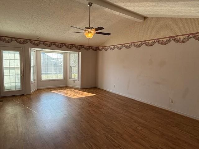 spare room with ceiling fan, dark hardwood / wood-style floors, vaulted ceiling with beams, and a textured ceiling