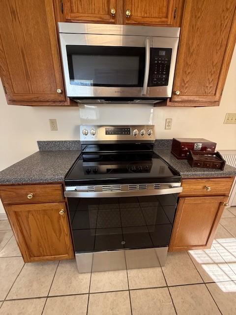 kitchen with light tile patterned flooring and appliances with stainless steel finishes