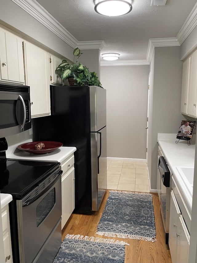 kitchen with white cabinetry, crown molding, light hardwood / wood-style flooring, a textured ceiling, and stainless steel appliances