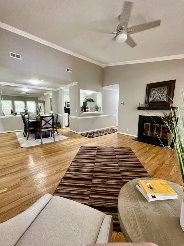 living room featuring crown molding, hardwood / wood-style floors, and ceiling fan