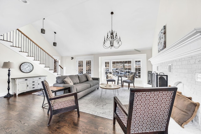 living room with a fireplace, dark wood-type flooring, high vaulted ceiling, and a chandelier